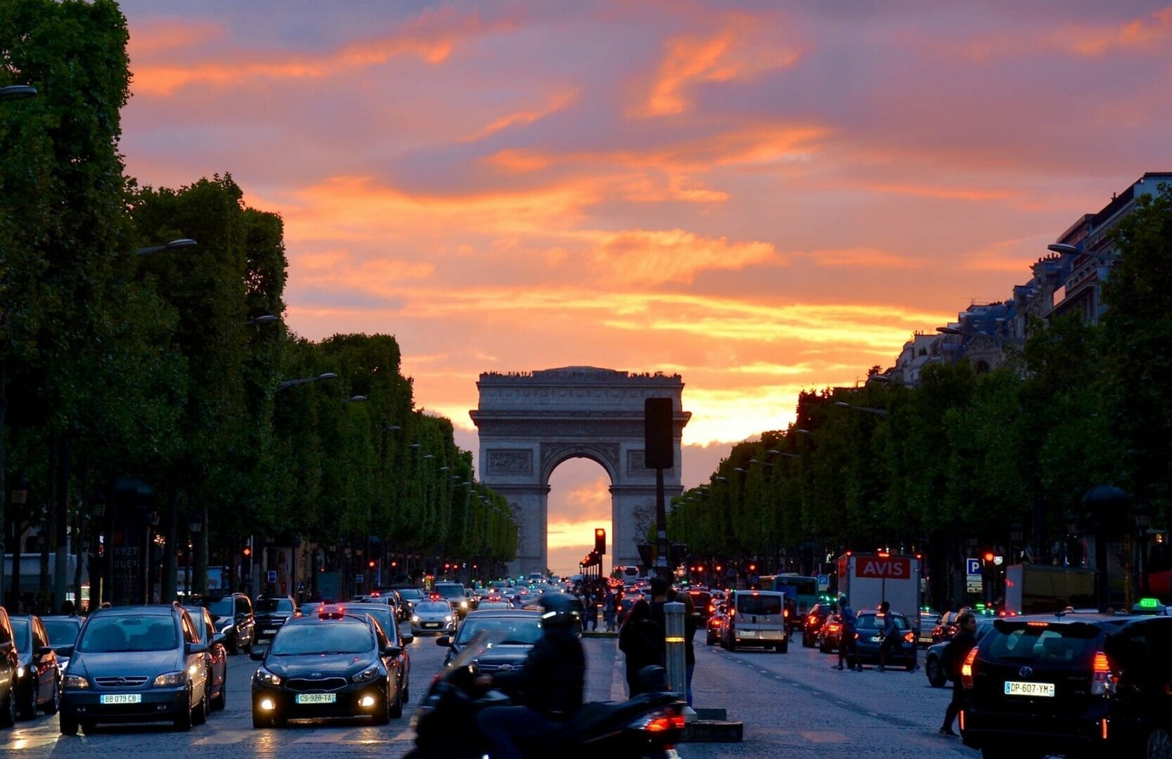 crowded street with cars along arc de triomphe - Best Places to Visit in Europe in June