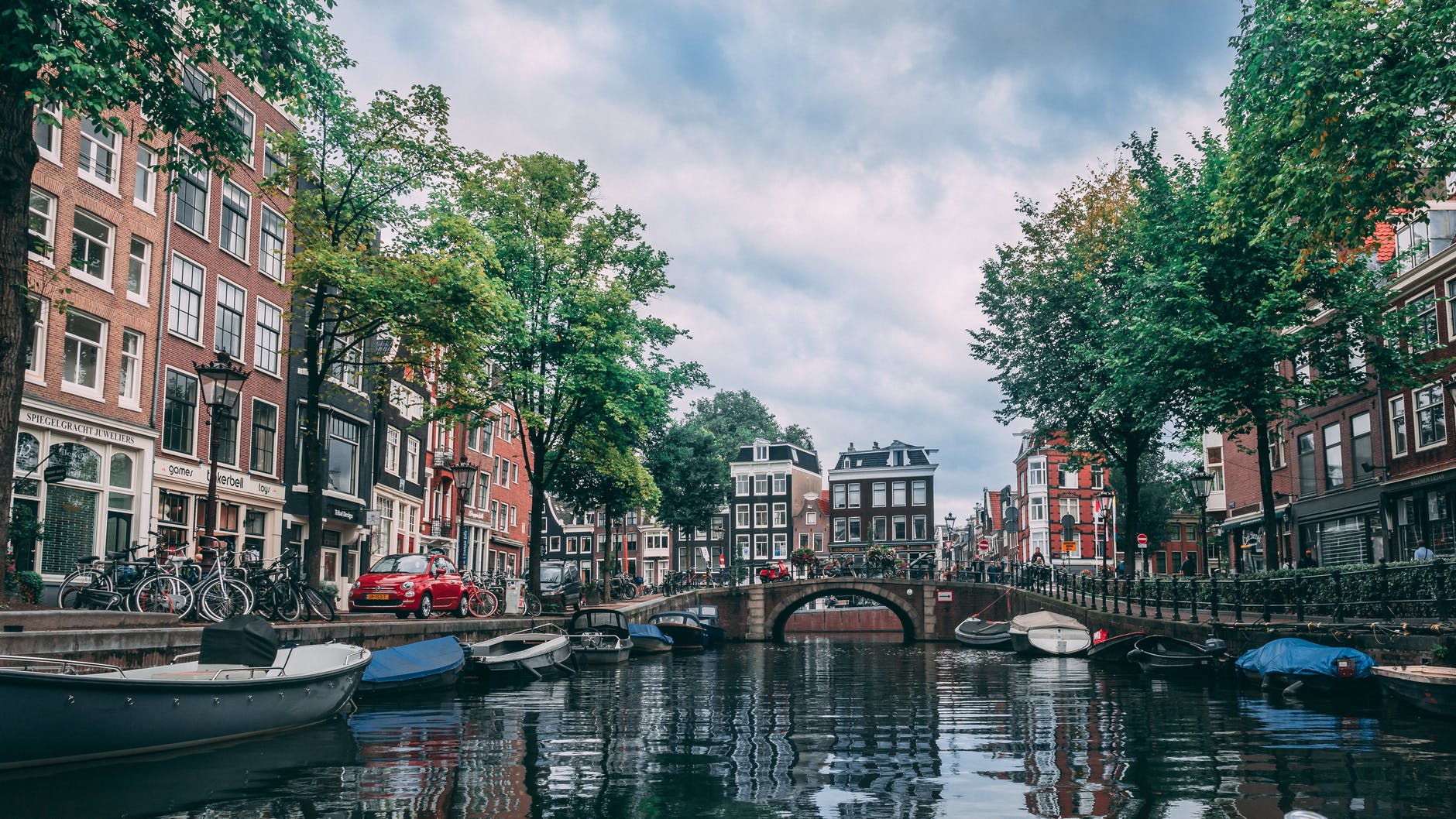 photo of boats parked on river - Places to visit in Europe in Summer - Amsterdam 