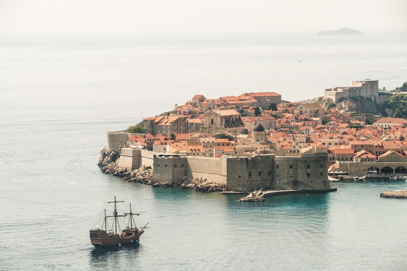 brown sailing ship near building