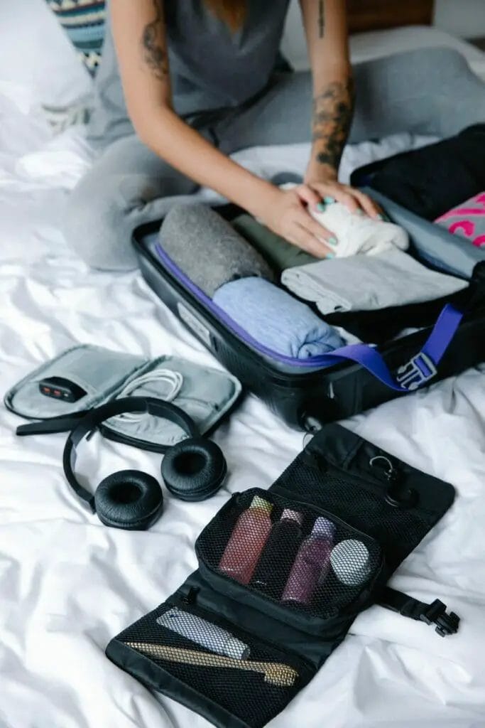 Auriculares negros al lado de una bolsa con artículos de tocador.