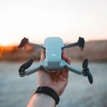 person holding gray and black quadcopter drone