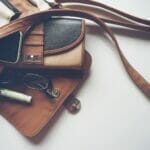 brown leather crossbody bag with eyeglasses