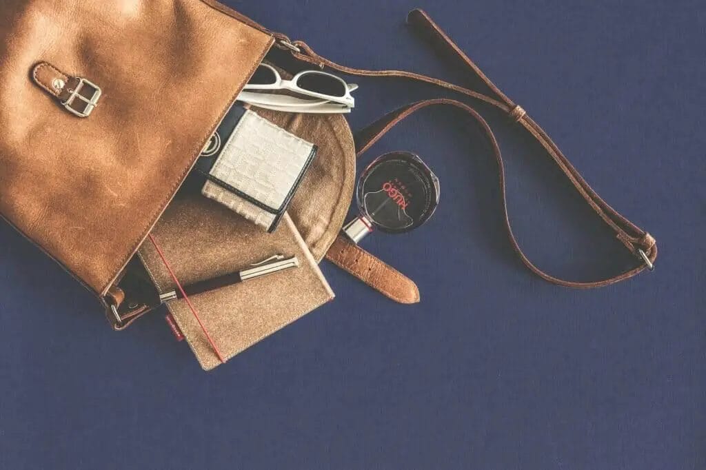 bolso bandolera de piel marrón con gafas de sol con montura blanca