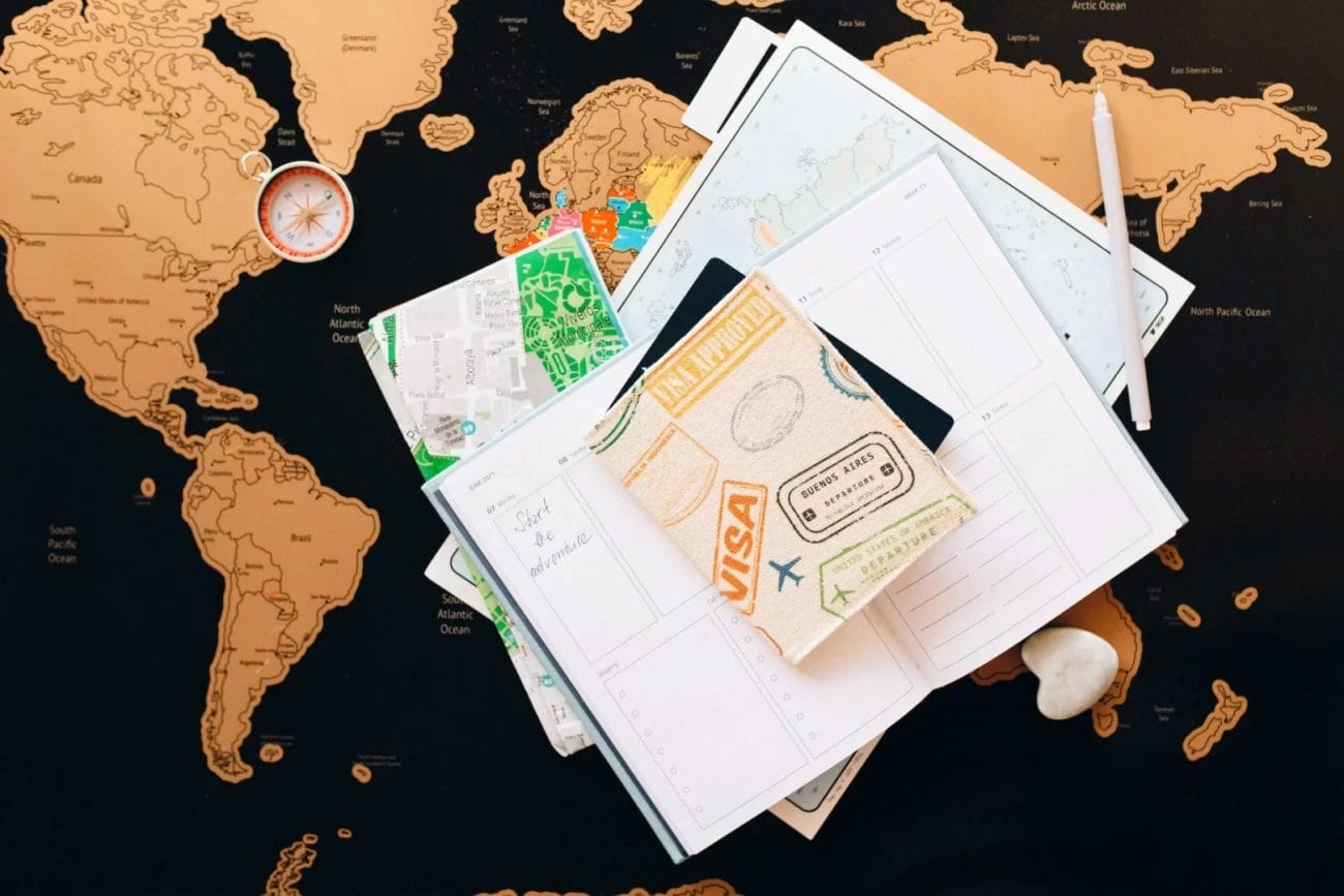 passport on top of a planner - Europe Travel Tips