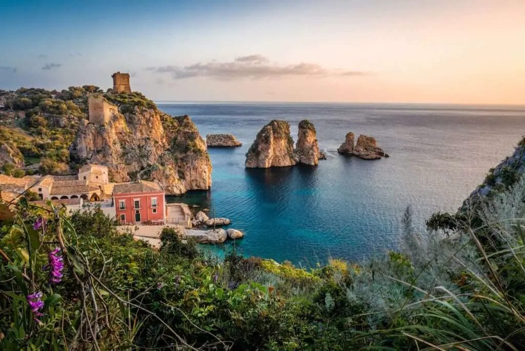 photo of house near cliff and body of water -- Easter in Sicily | Easter in Italy 2023
