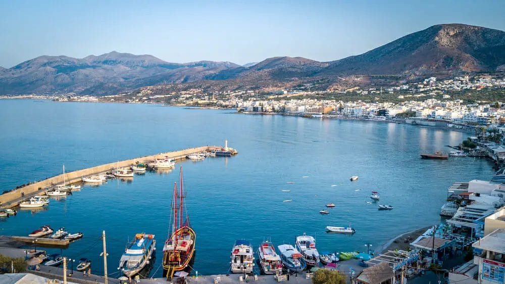 One of the top places to visit in Greece is a charming harbor with boats docked in it.