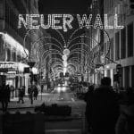 A black and white photo of people walking down a street with a sign that says never wall.