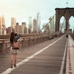 Una mujer está parada en el puente de Brooklyn.