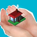 A person's hand holding a small house on a blue background.