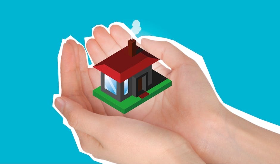 A person's hand holding a small house on a blue background.