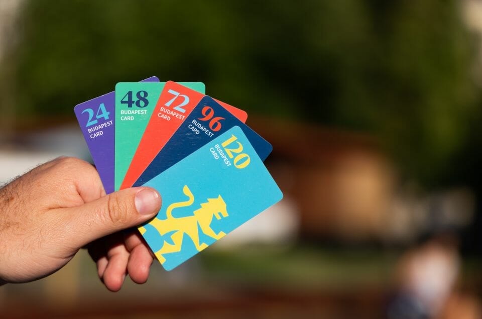 Una persona que muestra la Budapest Card con tarjetas vibrantes.