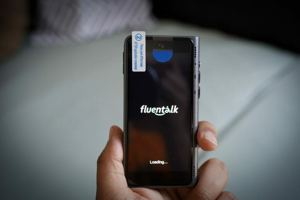 A hand holding a Fluentalk T1 Handheld Translator