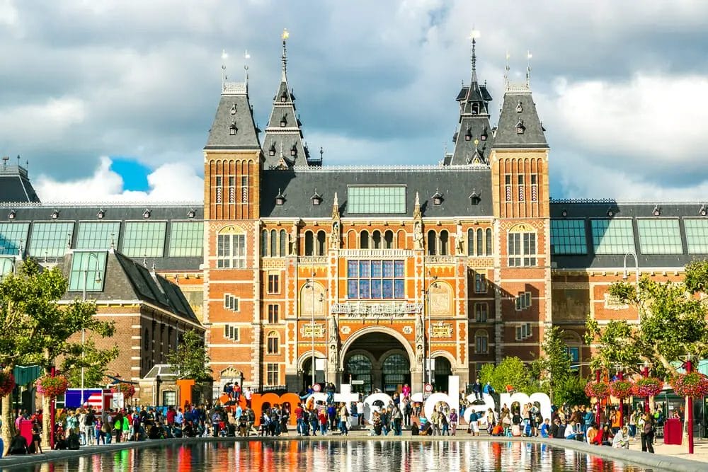 A group of people in Amsterdam standing in front of a large building.