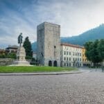 A square with a statue in the middle of it, one of the things to do in Como Italy.