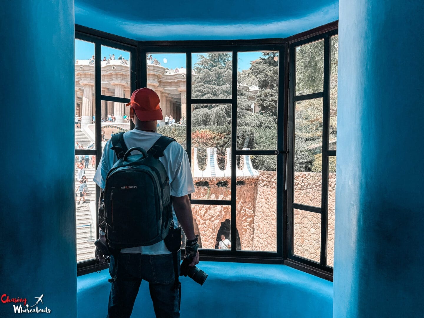 A man with a backpack looking out of a blue window.