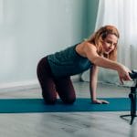 A woman practicing yoga on a mat, captured by a camera using one of the best smartphone gimbals.