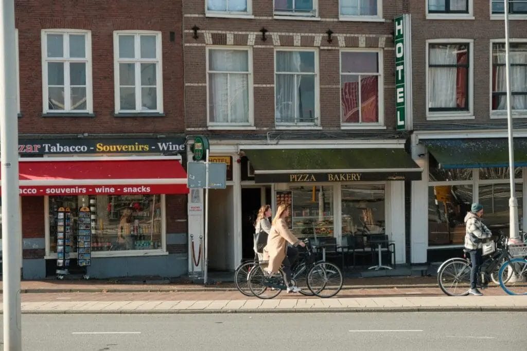 Descripción (modificada): Una mujer andando en bicicleta por una calle de Ámsterdam durante el festival de los tulipanes.