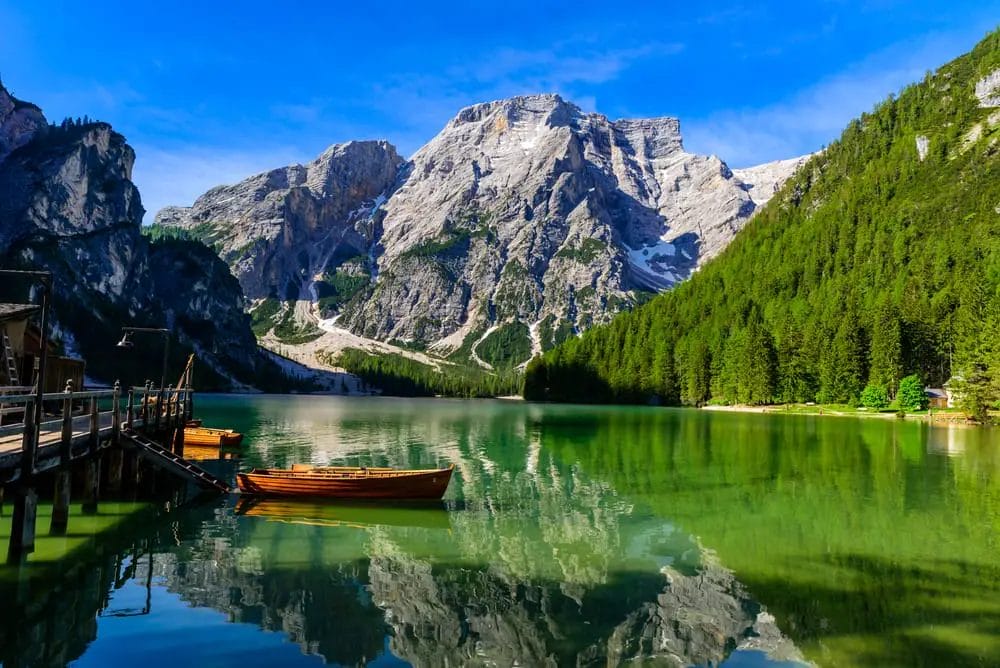 An ecotourism destination in Italy, featuring a serene lake nestled amidst majestic mountains.