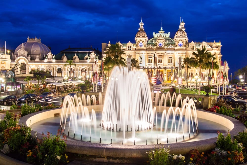 A fountain in front of a Casino at night in Monte Carlo.