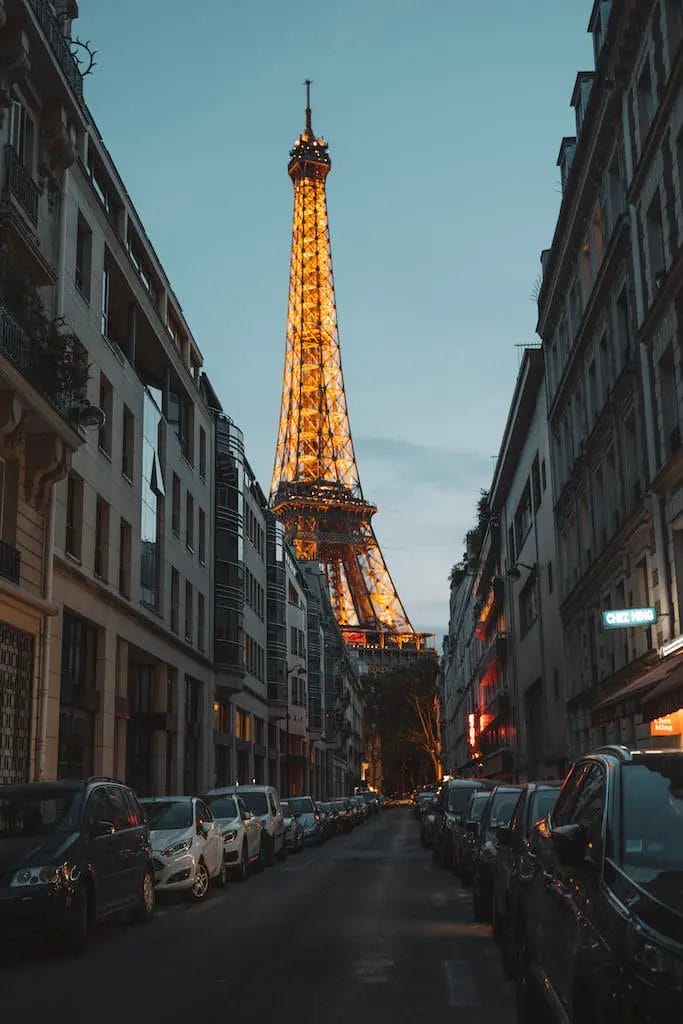 Foto di auto parcheggiate sul lato della strada di fronte alla Torre Eiffel