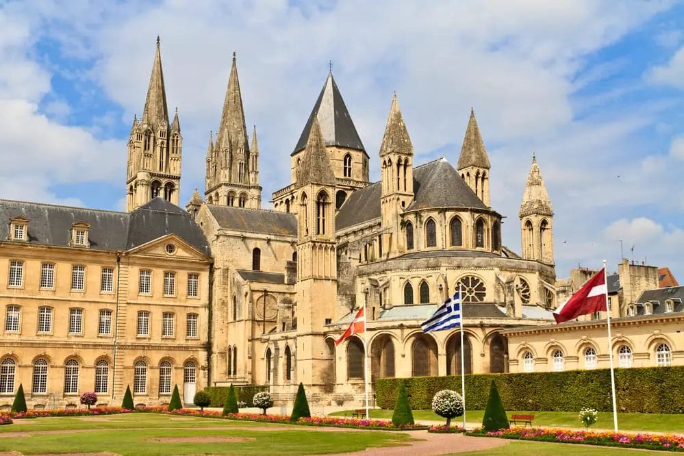 A large building with many spires is one of the places to visit in Normandy.