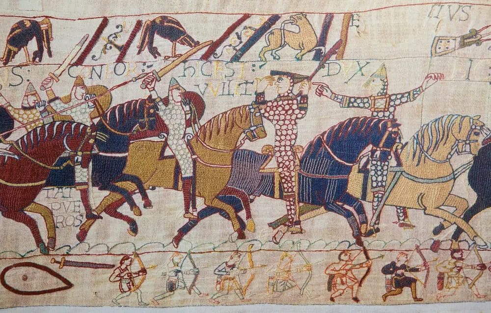 A tapestry depicting men on horses, illustrating places to visit in Normandy.