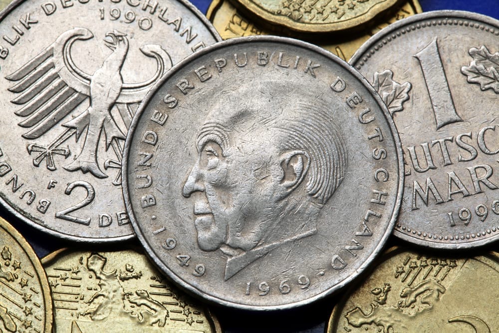 Eine Sammlung deutscher Münzen auf blauem Hintergrund.